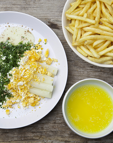 Dressage d'un plat d'asperges accompagné de frites au four