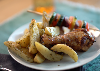 Quartiers de pommes de terre au romarin et au sel rose d’Himalaya, cuisses de poulet et brochettes de légumes d’hiver