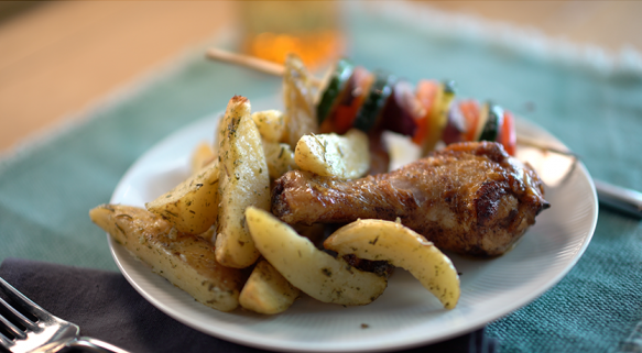 Quartiers de pommes de terre au romarin et au sel rose d’Himalaya, cuisses de poulet et brochettes de légumes d’hiver